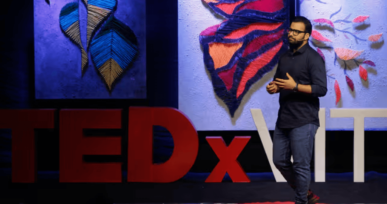 Nishkarsh at TEDx with colorful wall art